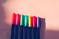 Conceptual still life of vibrant colored pens in a row