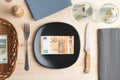 Conceptual studio shot of dinner table with euro bank notes on the plate instead of food. Concept for rising food prices Royalty Free Stock Photo