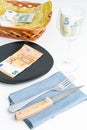 Conceptual studio shot of dinner table with euro bank notes on the plate instead of food. Concept for rising food prices Royalty Free Stock Photo