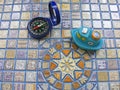 Conceptual travel toy ship and compass on mosaic background