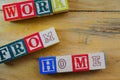 Conceptual of work from home during lockdown directives during virus outbreak. Wooden alphabet cubes forming WORKFROMHOME. Focus