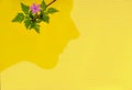 Conceptual work of man and nature. Flower and the silhouette of a man`s head on a yellow background