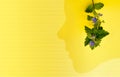 Conceptual work. Woman and nature. Flower and the silhouette of a woman head on a yellow background