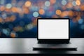 Conceptual workspace, Laptop computer with blank white screen on table, blurred background.