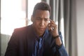 Concerned african American businessman have unpleasant cellphone talk