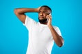 Concerned African American Man Talking On Phone Over Blue Background Royalty Free Stock Photo