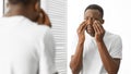 Concerned African Man Touching Bags Under Eyes Standing In Bathroom Royalty Free Stock Photo