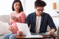 Concerned Asian Couple Calculating Expenses Looking At Bills At Home Royalty Free Stock Photo