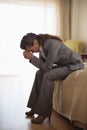 Concerned business woman sitting on bed in room Royalty Free Stock Photo