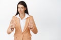 Concerned businesswoman telling to stop, showing prohibit, taboo gesture, restrict someone, standing in suit against