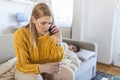Concerned, Caucasian blonde mother on phone and reading thermometer while her kid, son lies sick in bed resting Royalty Free Stock Photo