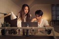 Concerned couple looking at a laptop screen in a softly lit room, both man and woman appears stressed