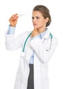 Concerned doctor woman looking on thermometer