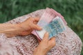 Concerned elderly woman counting Ukrainian money hryvnia.