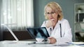 Concerned female pulmonologist examining X-ray of patient's lungs, diagnostics Royalty Free Stock Photo