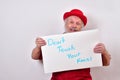 Worried old man holding up a sign that says Don`t touch your face