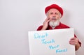 Concerned gentleman is toughing his face while holding a sign that says DON`T TOUCH YOUR FACE.