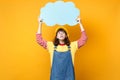 Concerned girl teenager in french beret, denim sundress looking up on blue empty blank Say cloud, speech bubble isolated Royalty Free Stock Photo