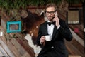 Concerned groom holding a cup and talking on his phone