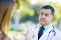 Concerned Hispanic Male Doctor or Nurse Listening to a Patient Royalty Free Stock Photo