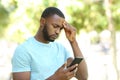 Concerned man with black skin checking phone Royalty Free Stock Photo