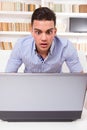 Concerned man looking at computer monitor shocked Royalty Free Stock Photo