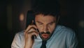 Concerned manager arguing telephone call sitting office late evening close up Royalty Free Stock Photo