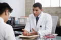 Concerned mixed race male doctor counselling male patient Royalty Free Stock Photo