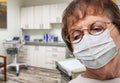 Concerned Senior Adult Woman Wearing Medical Face Mask Waiting In Doctor Office