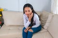 Concerned woman at home, sitting on the couch, concept of depression