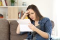 Concerned woman reading bad news in a letter