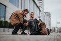 Young business professionals helping a colleague who fell on city street Royalty Free Stock Photo