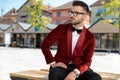 Concerned young elegant man sitting on wooden bench Royalty Free Stock Photo