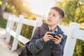 Concerned Young Hispanic Boy Walking With Backpack Holding Cell Phone Royalty Free Stock Photo