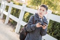 Concerned Young Hispanic Boy Walking With Backpack Holding Cell Phone Royalty Free Stock Photo