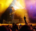 Concert, audience and hands in crowd with band for music festival, night club and dancing with light. Disco, party and Royalty Free Stock Photo