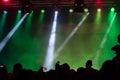 Concert crowd attending a concert, people silhouettes are visible, backlit by stage lights. Raised hands and smart phones are visi Royalty Free Stock Photo