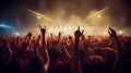 Concert crowd attending a concert, people silhouettes are visible, backlit by stage lights. Raised hands and smart Royalty Free Stock Photo