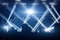 Concert crowd. People silhouettes in front of bright stage lights. Band of rock stars.