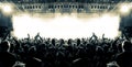 Concert crowd silhouettes in front of a bright stage