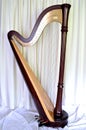 Concert grand pedal harp against white curtains