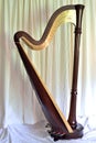 Concert grand pedal harp against white curtains