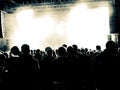 Concert hall with people clapping a band stage