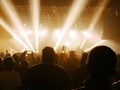 Concert hall with people clapping a band stage