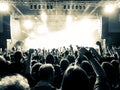 Concert hall with people clapping a band stage