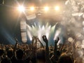 Concert hall with a wide crowd clapping in front of a stage