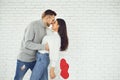 Concert Valentine`s Day. Young couple kissing with hearts in hands on a white brick background