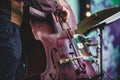 Concert view of a contrabass violoncello player with vocalist and musical during jazz orchestra band performing music,