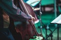 Concert view of a contrabass violoncello player with vocalist and musical during jazz orchestra band performing music,