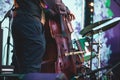 Concert view of a contrabass violoncello player with vocalist and musical during jazz orchestra band performing music,